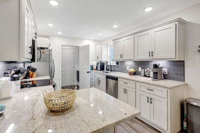 3128 Crow Rd NE, Dalton, GA 30721 - kitchen with appliances with stainless steel finishes, a sink, backsplash, light stone counters, and white cabinetry