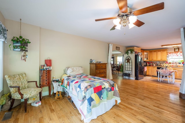222 Bennie Camp Rd, Dunlap, TN 37327 - bedroom featuring stainless steel fridge with ice dispenser, light wood-style floors, arched walkways, and ceiling fan