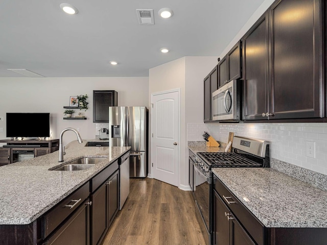 7231 Carrie Ct, Antioch, TN 37013 - kitchen featuring appliances with stainless steel finishes, a sink, dark brown cabinetry, light stone counters, and recessed lighting