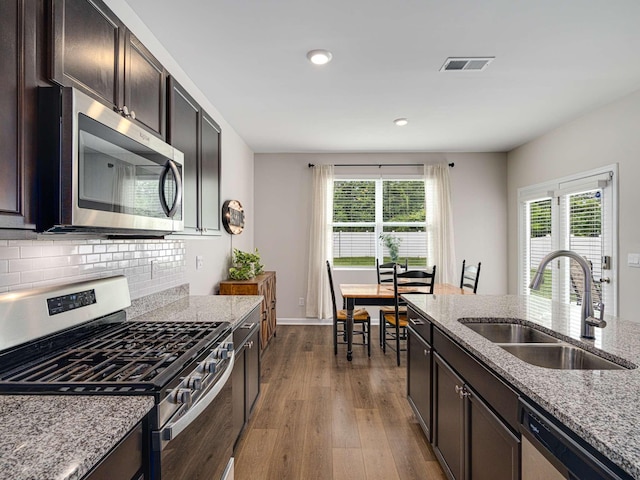 7231 Carrie Ct, Antioch, TN 37013 - kitchen with appliances with stainless steel finishes, a sink, dark wood-style flooring, light stone countertops, and recessed lighting