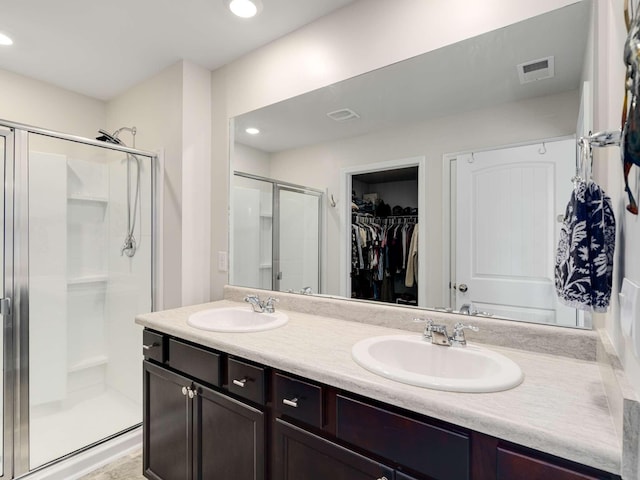 7231 Carrie Ct, Antioch, TN 37013 - bathroom featuring a shower stall, a walk in closet, double vanity, and recessed lighting