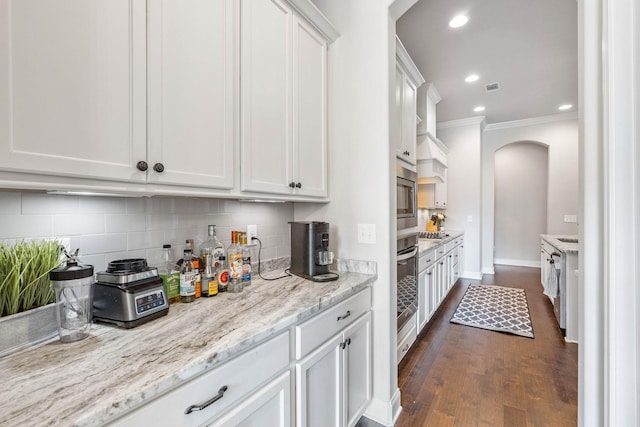 1210 Proprietors Pl, Murfreesboro, TN 37128 - kitchen featuring arched walkways, ornamental molding, white cabinetry, decorative backsplash, and dark wood-type flooring