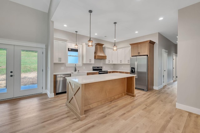 53 Kemp Hollow Rd, Pleasant Shade, TN 37145 - kitchen with stainless steel appliances, custom exhaust hood, light countertops, a center island, and french doors