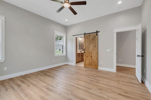 53 Kemp Hollow Rd, Pleasant Shade, TN 37145 - unfurnished bedroom featuring a barn door, light wood finished floors, recessed lighting, connected bathroom, and a ceiling fan