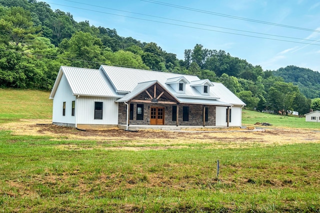 53 Kemp Hollow Rd, Pleasant Shade, TN 37145 - view of front facade with a porch, a front lawn, stone siding, a metal roof, and a forest view