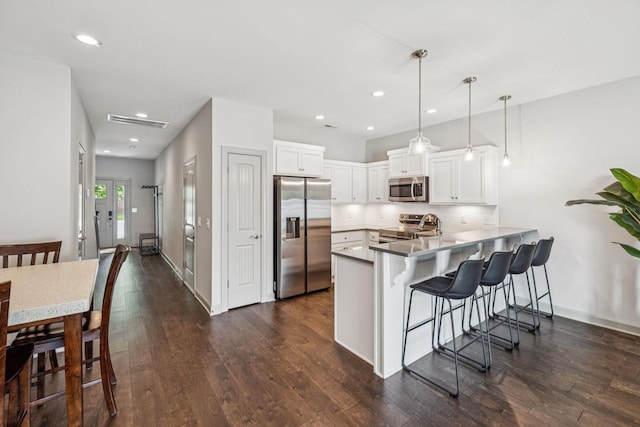 2342 N Tennessee Blvd Unit 1203, Murfreesboro, TN 37130 - kitchen with appliances with stainless steel finishes, a peninsula, a kitchen breakfast bar, white cabinetry, and dark wood-style flooring
