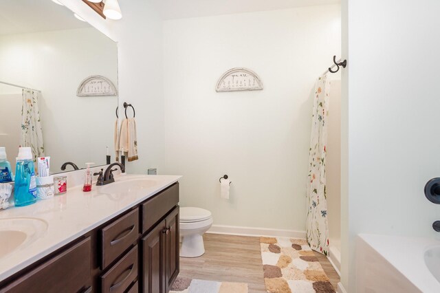 3045 Tacoma Ln, Goodlettsville, TN 37072 - full bathroom with double vanity, toilet, wood finished floors, and baseboards