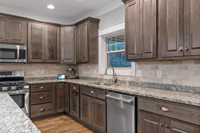 808 Willcrest Dr, Chattanooga, TN 37405 - kitchen featuring stainless steel appliances, a sink, crown molding, dark brown cabinetry, and tasteful backsplash