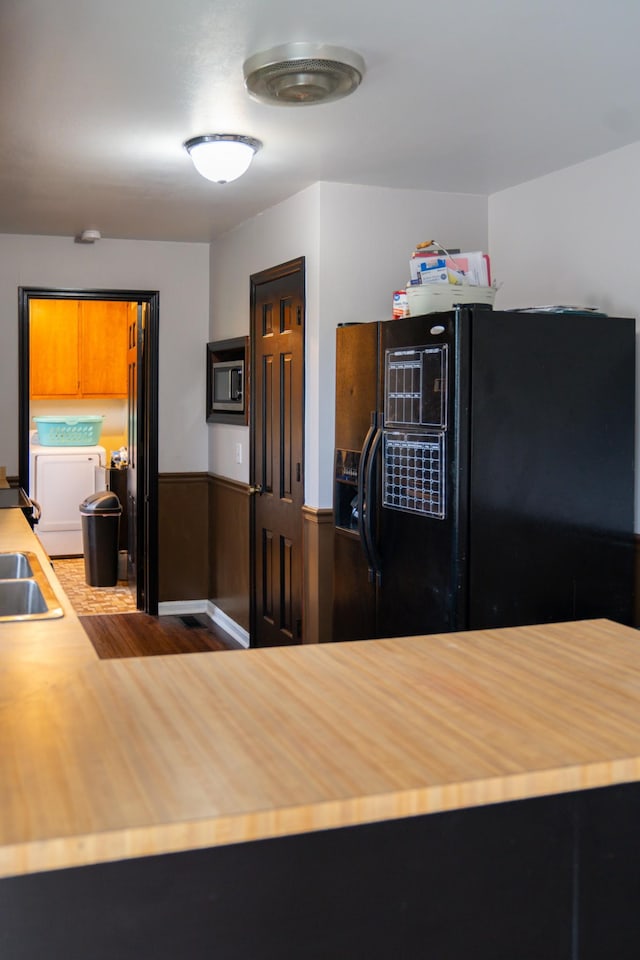 4169 Bledsoe St, Westmoreland, TN 37186 - kitchen with black fridge with ice dispenser, washer and dryer, a wainscoted wall, wooden counters, and dark wood finished floors