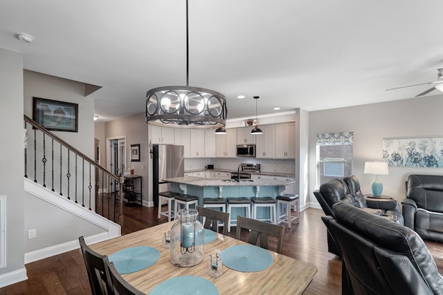 566 Oakvale Ln, Mount Juliet, TN 37122 - dining space with a ceiling fan, stairway, baseboards, dark wood-style flooring, and a chandelier