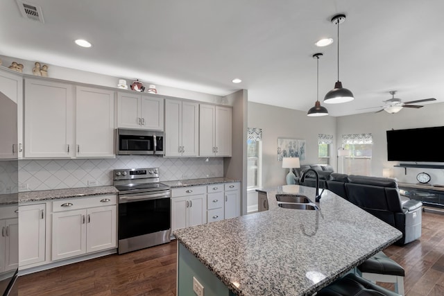 566 Oakvale Ln, Mount Juliet, TN 37122 - kitchen featuring appliances with stainless steel finishes, a sink, open floor plan, dark wood finished floors, and decorative backsplash