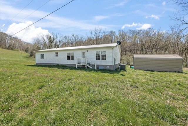 125 Fitzgerald Ave, Celina, TN 38551 - back of property with central AC, a yard, and metal roof