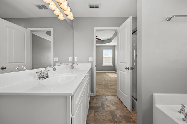 1113 Dunkirk Ln, Murfreesboro, TN 37129 - bathroom featuring double vanity, stone finish floors, a bathtub, and baseboards