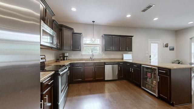 5127 Heroes Ln, Murfreesboro, TN 37129 - kitchen featuring appliances with stainless steel finishes, a peninsula, a sink, beverage cooler, and dark wood finished floors