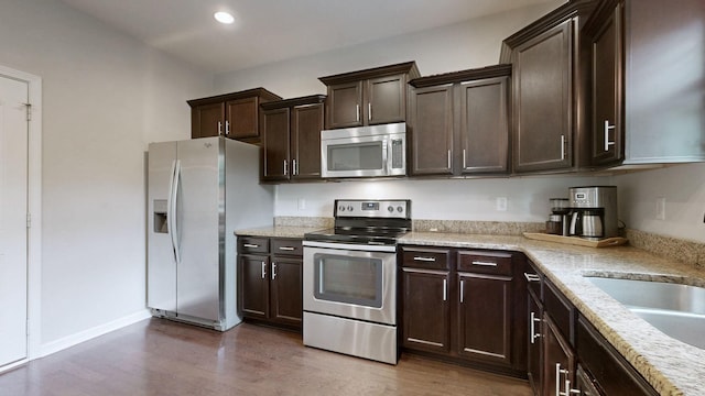 5127 Heroes Ln, Murfreesboro, TN 37129 - kitchen with appliances with stainless steel finishes, dark wood finished floors, dark brown cabinetry, recessed lighting, and baseboards