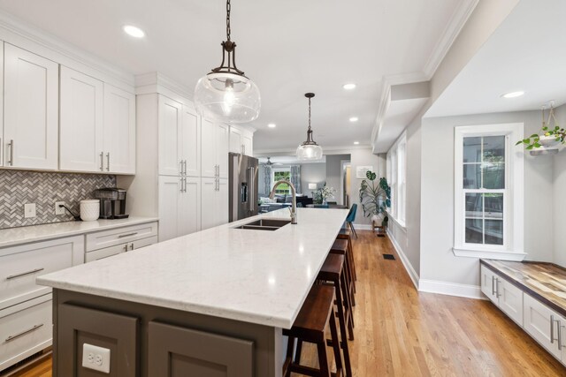 303 Avondale Dr, Franklin, TN 37064 - kitchen featuring high end fridge, decorative backsplash, a sink, an island with sink, and baseboards
