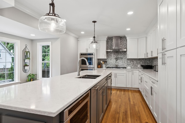 303 Avondale Dr, Franklin, TN 37064 - kitchen with wall chimney exhaust hood, decorative backsplash, white cabinetry, crown molding, and light wood-style floors