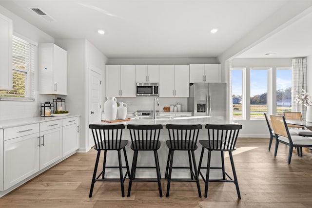 7218 Hanworth St, Fairview, TN 37062 - kitchen featuring appliances with stainless steel finishes, an island with sink, a sink, a breakfast bar, and backsplash