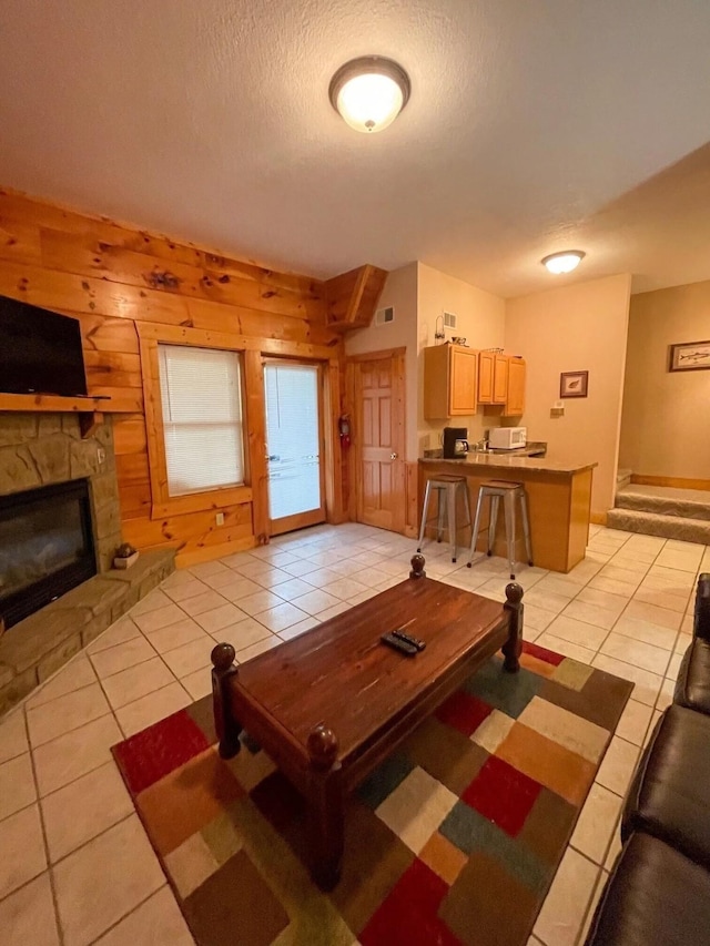 839 Golf View Blvd, Pigeon Forge, TN 37863 - living room with light tile patterned flooring, a fireplace, a textured ceiling, and wood walls