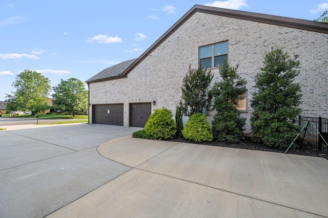 2743 Crowne Pointe Dr, Murfreesboro, TN 37130 - view of property exterior featuring driveway, a garage, and brick siding