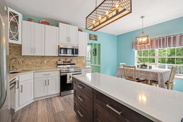 1514 Cardinal Ln, Mount Juliet, TN 37122 - kitchen featuring appliances with stainless steel finishes, light countertops, light wood finished floors, and white cabinetry
