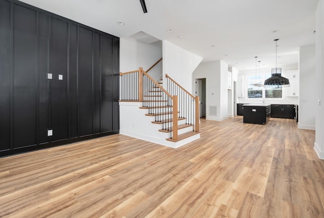107 E 9th St Unit D7, Columbia, TN 38401 - unfurnished living room featuring light wood-style floors, stairs, and baseboards