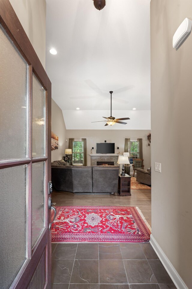 3006 Gracie Ann Dr, Greenbrier, TN 37073 - living room featuring a ceiling fan, vaulted ceiling, a lit fireplace, and baseboards