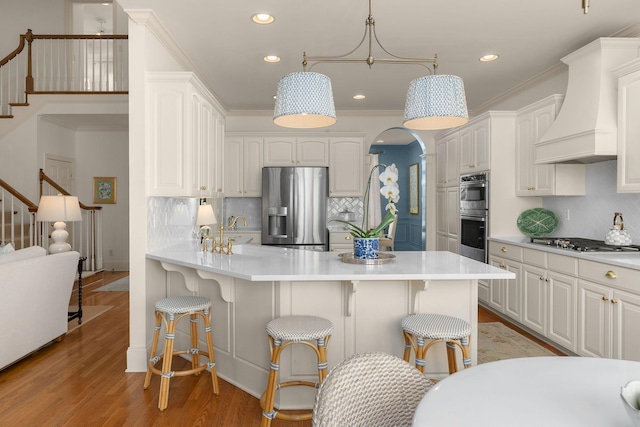 403 Butterfly Ct, Franklin, TN 37069 - kitchen with stainless steel appliances, custom range hood, a peninsula, a kitchen bar, and recessed lighting