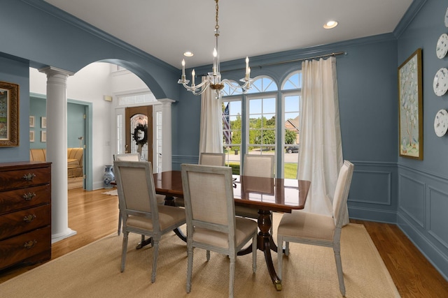 403 Butterfly Ct, Franklin, TN 37069 - dining room with decorative columns, arched walkways, crown molding, wood finished floors, and a decorative wall