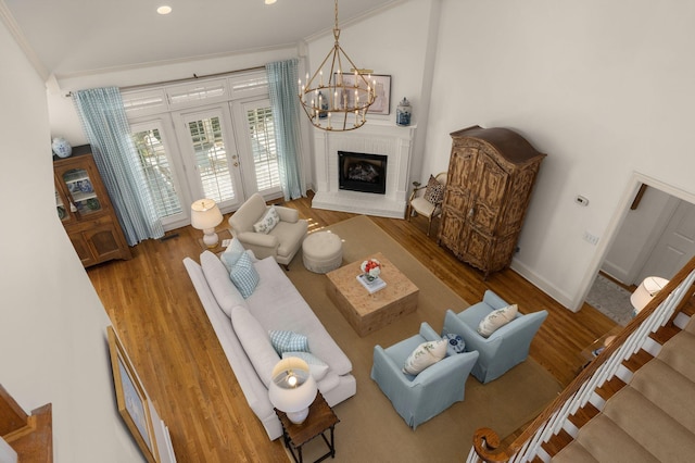 403 Butterfly Ct, Franklin, TN 37069 - living room featuring a chandelier, wood finished floors, baseboards, crown molding, and a fireplace