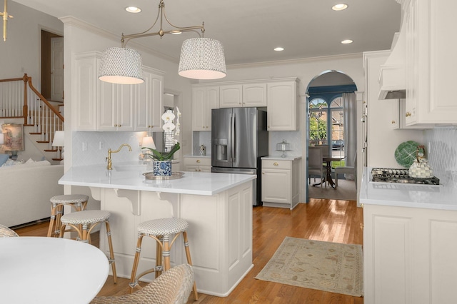 403 Butterfly Ct, Franklin, TN 37069 - kitchen with appliances with stainless steel finishes, arched walkways, a peninsula, backsplash, and a breakfast bar area