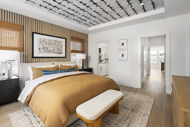 336 Hutcherson Aly, Nashville, TN 37209 - bedroom with baseboards, a raised ceiling, light wood-type flooring, and ensuite bath