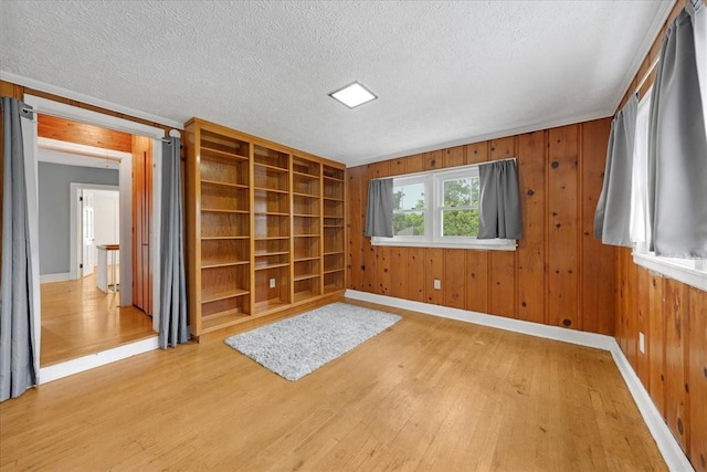 412 Cumberland St E, Cowan, TN 37318 - empty room featuring light wood-style flooring, a textured ceiling, and wooden walls