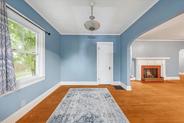 412 Cumberland St E, Cowan, TN 37318 - foyer entrance with a textured ceiling, arched walkways, wood finished floors, and a brick fireplace