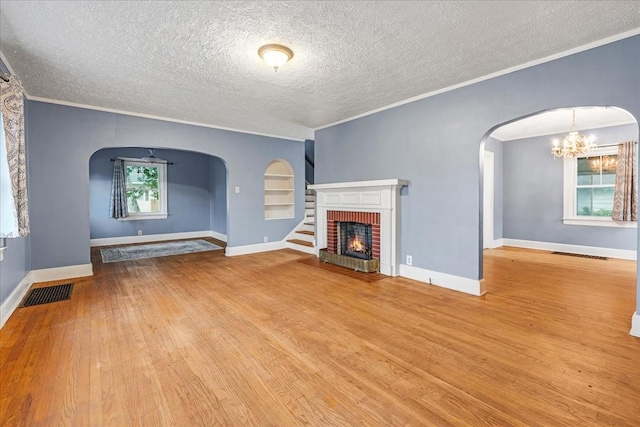 412 Cumberland St E, Cowan, TN 37318 - unfurnished living room featuring arched walkways, ornamental molding, wood finished floors, a textured ceiling, and a fireplace