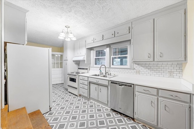 412 Cumberland St E, Cowan, TN 37318 - kitchen with white appliances, a chandelier, under cabinet range hood, tasteful backsplash, and light countertops