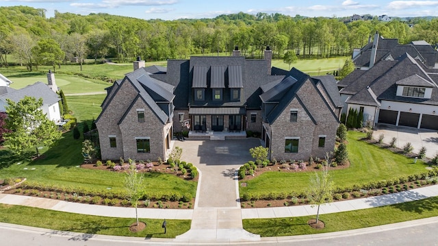 7212 Shagbark Ln, College Grove, TN 37046 - view of front of home with a chimney, stone siding, driveway, a front yard, and a view of trees