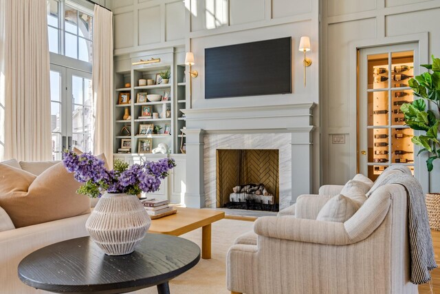 7212 Shagbark Ln, College Grove, TN 37046 - living room with a decorative wall, built in shelves, a fireplace, a towering ceiling, and wood finished floors