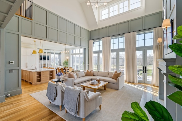 7212 Shagbark Ln, College Grove, TN 37046 - living area with a decorative wall, a chandelier, a high ceiling, and light wood-style flooring