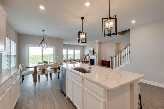 1207 Bridgett Way, Mount Juliet, TN 37122 - kitchen featuring a sink, dishwasher, wood finished floors, a fireplace, and a chandelier