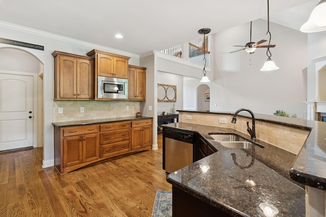 4181 Miles Johnson Pkwy, Spring Hill, TN 37174 - kitchen featuring appliances with stainless steel finishes, a sink, arched walkways, ceiling fan, and ornamental molding