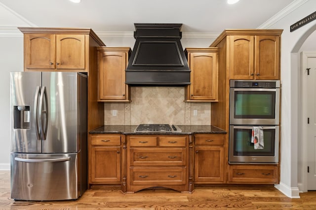 4181 Miles Johnson Pkwy, Spring Hill, TN 37174 - kitchen with appliances with stainless steel finishes, custom range hood, arched walkways, dark stone countertops, and ornamental molding