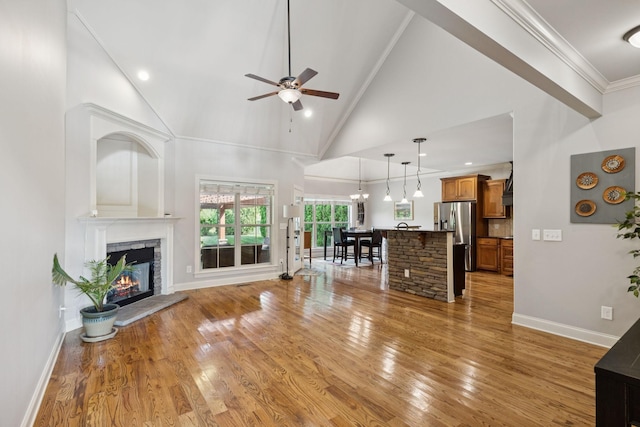 4181 Miles Johnson Pkwy, Spring Hill, TN 37174 - living room featuring ceiling fan, a fireplace, light wood-type flooring, baseboards, and ornamental molding