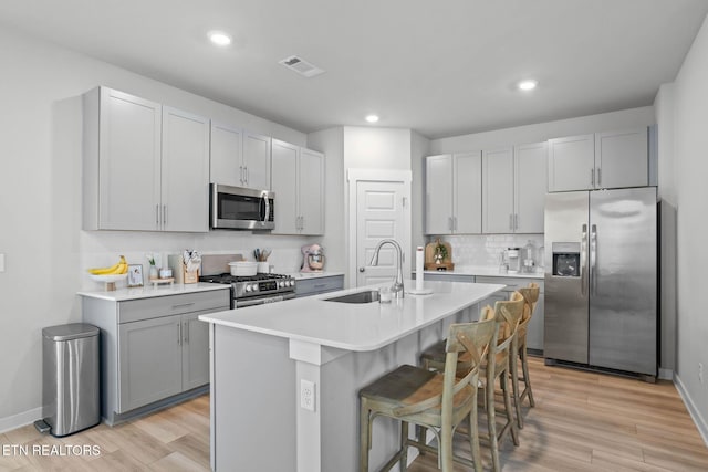 324 Gulfstream Dr, Gallatin, TN 37066 - kitchen with stainless steel appliances, a sink, a kitchen breakfast bar, light wood-style floors, and recessed lighting