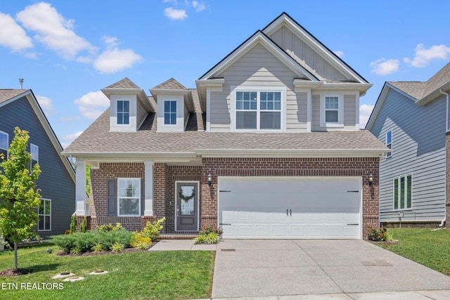 324 Gulfstream Dr, Gallatin, TN 37066 - view of front of home featuring a shingled roof, brick siding, driveway, a front yard, and board and batten siding