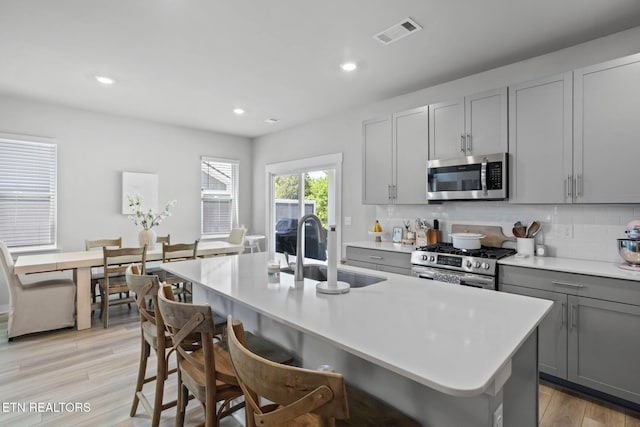 324 Gulfstream Dr, Gallatin, TN 37066 - kitchen featuring stainless steel appliances, gray cabinets, a sink, tasteful backsplash, and light countertops