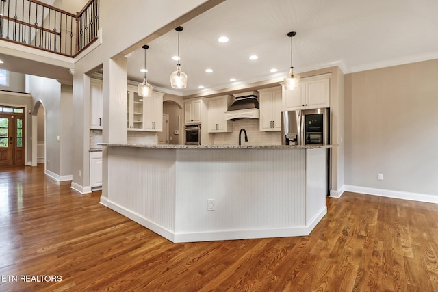 550 Stone Villa Ln, Knoxville, TN 37934 - kitchen featuring stainless steel appliances, arched walkways, tasteful backsplash, custom range hood, and white cabinetry