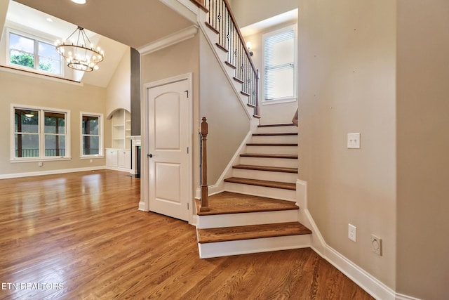 550 Stone Villa Ln, Knoxville, TN 37934 - stairs featuring a chandelier, baseboards, wood finished floors, and a high ceiling