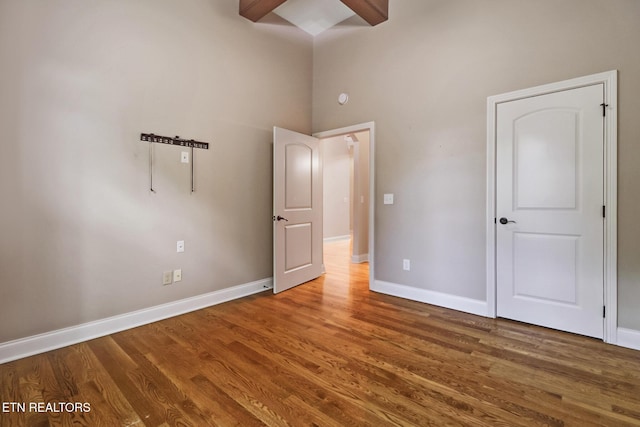 550 Stone Villa Ln, Knoxville, TN 37934 - unfurnished bedroom featuring baseboards, wood finished floors, high vaulted ceiling, and beamed ceiling