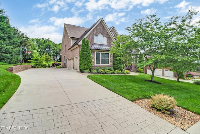 550 Stone Villa Ln, Knoxville, TN 37934 - view of front of house with driveway, a front yard, brick siding, a garage, and a standing seam roof